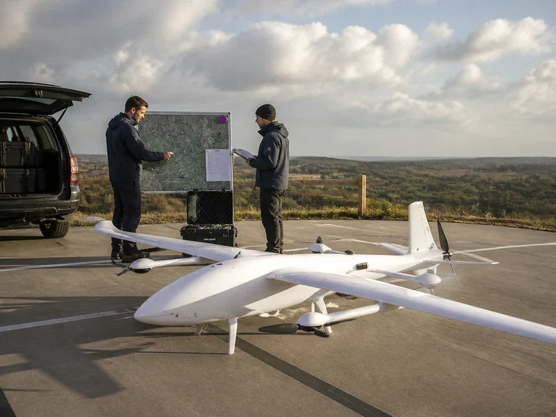 Complete UG32 fixed-wing VTOL at a corridor patrol staging pad during a route-change review