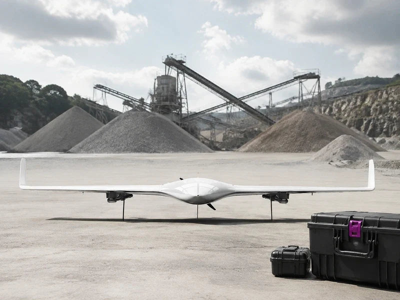 Front-facing complete UG21 on a quarry staging apron with distant stockpiles and conveyors.