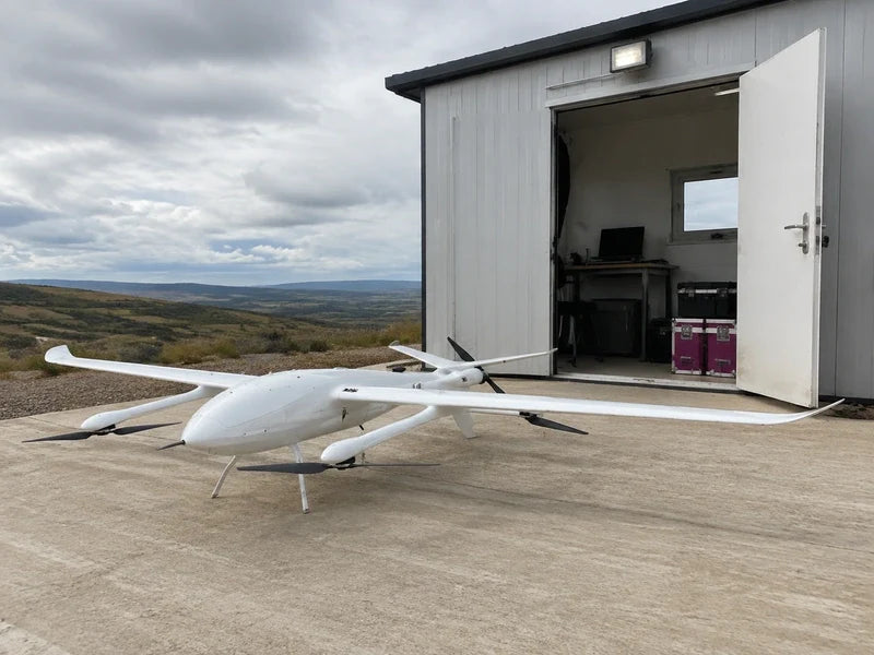 Complete UG39 parked outside a remote survey cabin with an offline data workstation visible through an open door.