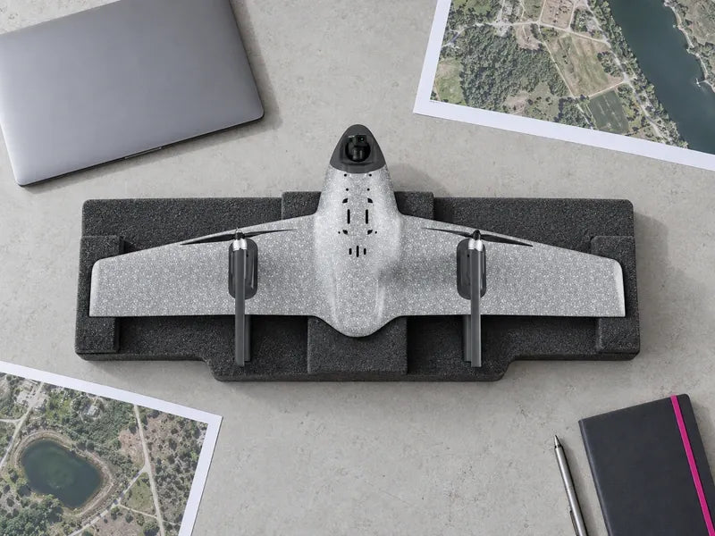Complete UVH1 supported on a light survey-office table beside a closed laptop and map prints