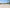 UG25 in its approved three-quarter view on a spacious pale stone terrace beside a tall glass wall, distant vegetation and a separate date-free site plan stand