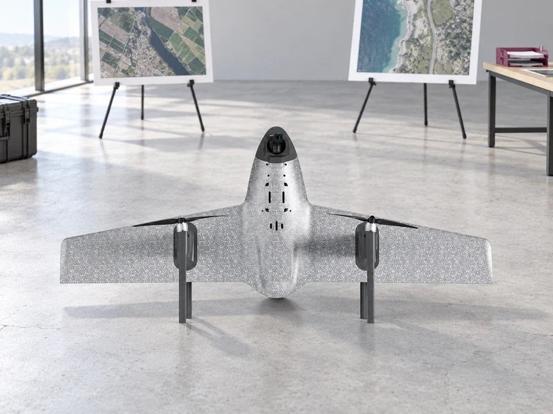UVH1 in the exact approved perspective on an open survey-studio floor with two separate aerial-photo review easels well behind the aircraft and a muted magenta document tray