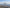 UG73 in exact straight rear view with complete wings visible above a quiet terraced rocky plateau, cool morning daylight