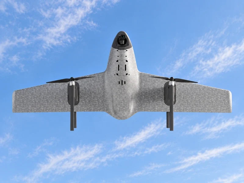 UVH1 in exact underside view with camera nose pointing upward in frame against a pale cloud-striped sky, complete wings and dark nacelles visible