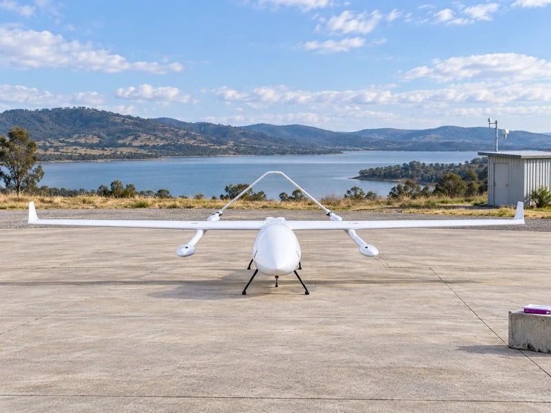 UG62 stationary on a broad rural service apron near a reservoir, frontal view with no people or cargo.