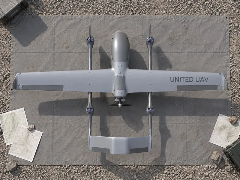 UG73 directly overhead on a gray survey staging mat with small contour printouts outside the airframe