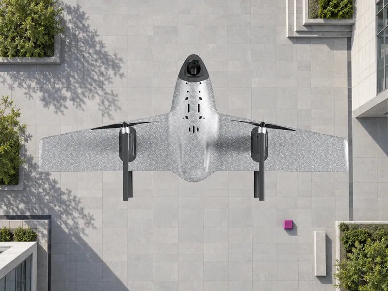 UVH1 exact overhead reference orientation above a broad empty pale-gray tiled geospatial campus courtyard, small magenta marker far below