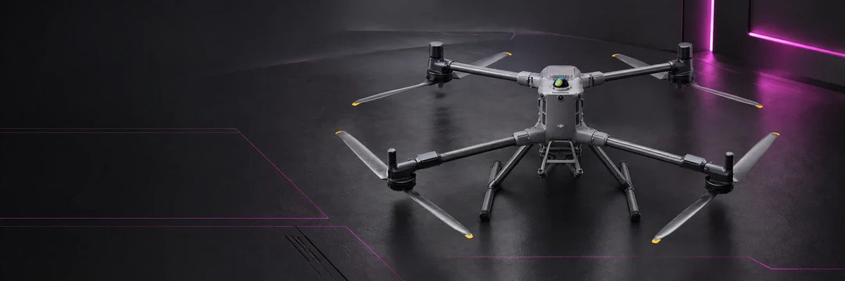 DJI Matrice 400 enterprise drone with carbon-fiber arms and landing gear in a dark graphite studio with magenta accents.